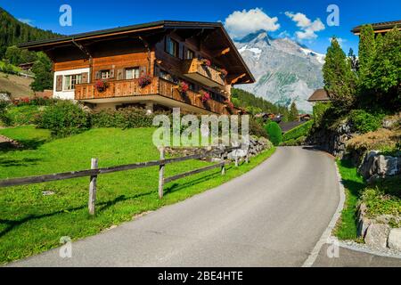 Vue sur la rue, avec des lodges en bois et des jardins ornementaux fleuris dans la station de montagne Grindelwald, Oberland bernois, Suisse, Europe Banque D'Images