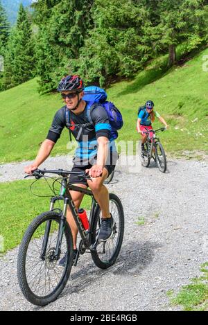 Jeunes cyclistes en montée avec VTT sur route de gravier Banque D'Images