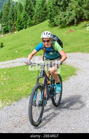 Jeune femme avec ascendant mountainbike sur gravier Banque D'Images
