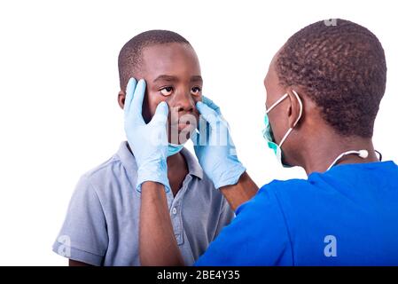 jeune médecin en uniforme examinant les yeux d'un petit garçon à l'hôpital. Banque D'Images