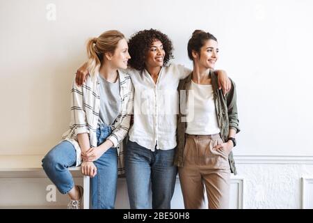 Happy girls standing au mur blanc à l'intérieur Banque D'Images