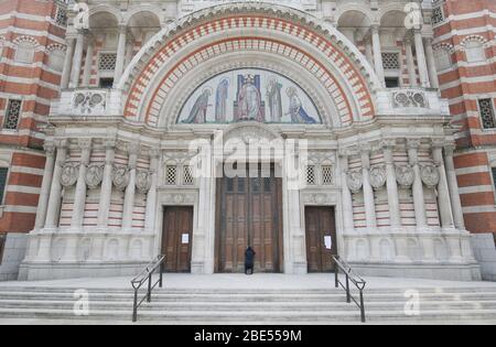 Une femme prie à la porte fermée de la cathédrale de Westminster devant la messe du matin de Pâques, Londres, alors que le Royaume-Uni continue de se verrouiller pour aider à freiner la propagation du coronavirus. Les églises de tout le pays continuent de diffuser des services numériques jusqu'à Pâques, avec plus de 1 000 direct régulièrement. Banque D'Images