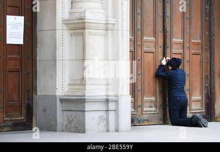 Une femme prie à la porte fermée de la cathédrale de Westminster devant la messe du matin de Pâques, Londres, alors que le Royaume-Uni continue de se verrouiller pour aider à freiner la propagation du coronavirus. Les églises de tout le pays continuent de diffuser des services numériques jusqu'à Pâques, avec plus de 1 000 direct régulièrement. Banque D'Images