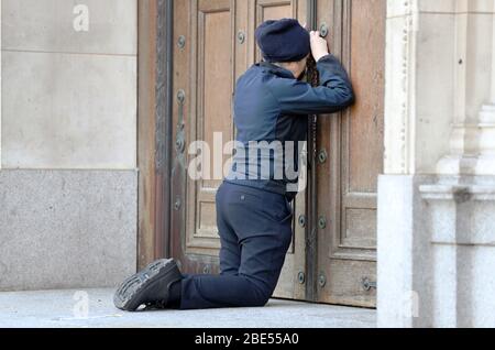 Une femme prie à la porte fermée de la cathédrale de Westminster devant la messe du matin de Pâques, Londres, alors que le Royaume-Uni continue de se verrouiller pour aider à freiner la propagation du coronavirus. Les églises de tout le pays continuent de diffuser des services numériques jusqu'à Pâques, avec plus de 1 000 direct régulièrement. Banque D'Images