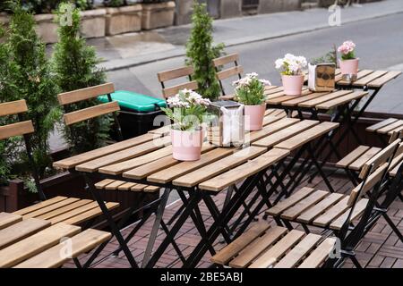 Des tables en bois sont dans la rue. Un café confortable. Un endroit pour se détendre. Fleurs sur la table Banque D'Images