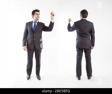 Le professionnel qui porte la combinaison a tendance à écrire sur la caméra à écran en tenant le marqueur avant et arrière vue Banque D'Images