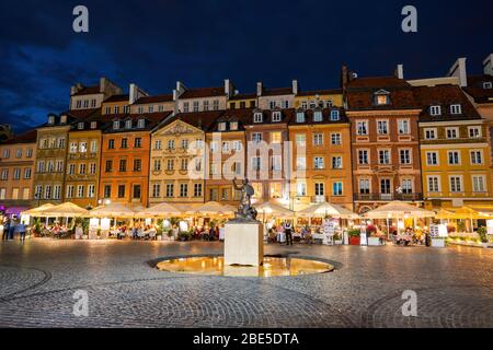 Place du marché de la vieille ville la nuit dans la ville de Varsovie en Pologne, maisons colorées, statue et fontaine de la sirène, site classé au patrimoine mondial de l'UNESCO Banque D'Images