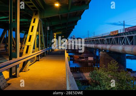 Pologne, ville de Varsovie, trottoir sur le pont Gdanski et le pont ferroviaire de la Citadelle sur la Vistule la nuit Banque D'Images