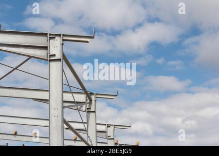 Structure de poutre en acier sur le nouveau bâtiment contre le ciel bleu avec des nuages. Construction rapide de bâtiments Banque D'Images