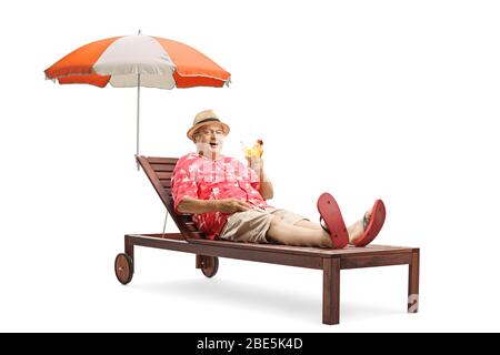 Homme mûr touristique avec une boisson cocktail sur un transat sous un parapluie isolé sur fond blanc Banque D'Images