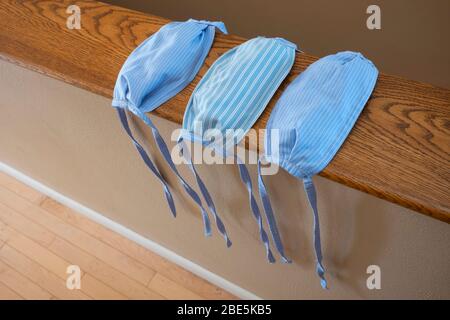 Un gros plan de trois masques cousus à la main, fabriqués à partir d'un tissu de coton à rayures bleues, sans bandes élastiques, pour éviter la propagation DU COVI Banque D'Images