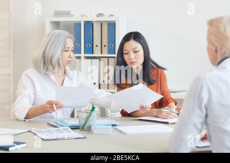 Portrait de la femme d'affaires senior ayant réussi à parler à des collègues plus jeunes lors d'une réunion dans la salle de conférence, espace de copie Banque D'Images