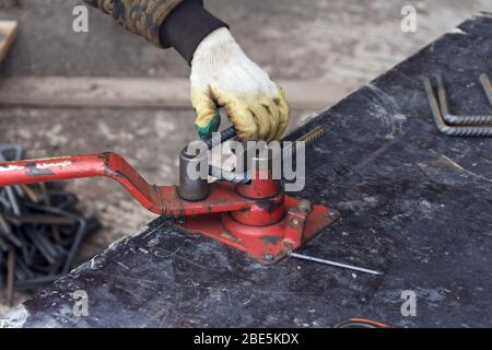 Barre d'armature métallique de flexion. Employé utilisant une machine à barre d'armature pour le renforcement dans les travaux de construction Banque D'Images