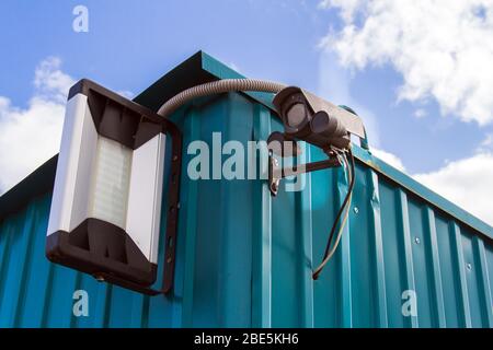 Caméra de sécurité sur fond bleu ciel. Caméra de surveillance pour la protection du territoire. Sécurité de la propriété privée. Banque D'Images