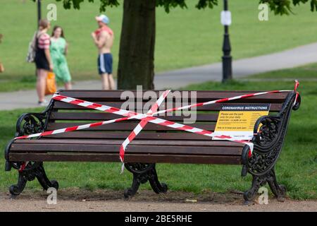 Londres, Royaume-Uni, 12 avril 2020: Le dimanche de Pâques, les gens observent les règles sociales de distanciation lorsqu'ils prennent de l'exercice et de l'air frais au soleil sur Clapham Common. Des bancs ont été fixés et des panneaux ont été affichés expliquant que les gens ne devraient marcher ou faire de l'exercice que lorsque l'extérieur. Anna Watson/ Alay Live News Banque D'Images