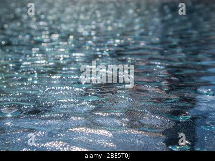 Motifs de vagues dans le verre du dessus de table pris par le soleil du matin Banque D'Images