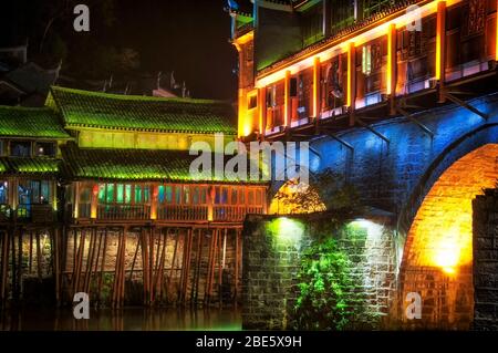 Le pont de hongqiao, un site touristique, s'est éclairé la nuit sur la rivière du tuojiang dans le village de Fenghuang, dans la province chinoise de hunan. Banque D'Images