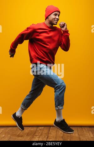 Portrait complet d'un jeune homme agréable et décontracté et heureux sautant sur fond jaune Banque D'Images