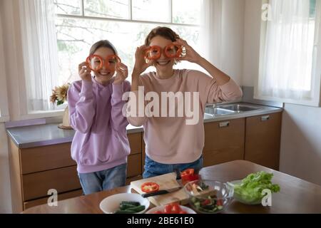 Drôle de la famille végétalienne heureux de faire des verres de poivre regardant l'appareil photo Banque D'Images