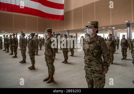 Les aviateurs de la Force aérienne américaine portent des masques de visage et pratiquent des distanciation sociale lors de leur graduation militaire de base au 321ème complexe d'entraînement de l'Escadron d'entraînement de la base commune San Antonio-Lackland le 9 avril 2020 à San Antonio, Texas. En raison de la COVID-19, pandémie de coronavirus, la cérémonie a été fermée au public et aux membres de la famille. Banque D'Images