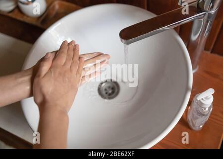 Femme se laver les mains à l'aide de savon au-dessus de l'évier de salle de bains, se rapprochez Banque D'Images