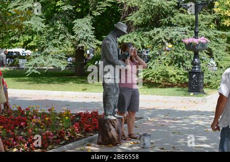 La jeune femme pose avec mime peint gris pour prendre la photo dans le parc sur Primorsky (Seaside)Blvd à Sébastopol, Crimée, Russie. Banque D'Images