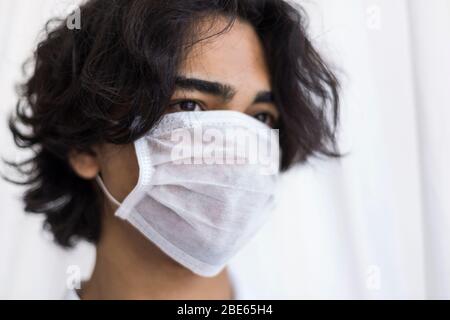 Un adolescent protégé portant un masque Banque D'Images