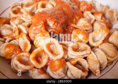 Délicieux plat de pâtes fraîches orecchietta et de la braciola de rouleau de viande avec sauce tomate. Cuisine typique d'Pouilles. Italie Banque D'Images