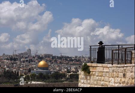 Jérusalem, Israël. 12 avril 2020. Un Juif ultra-orthodoxe prie sur le Mont d'Ovives, surplombant la vieille ville de Jérusalem, le dimanche 12 avril 2020. Le gouvernement israélien a déployé 1 000 policiers pour faire appliquer une fermeture complète aux quartiers religieux juifs avec le taux le plus élevé de coronavirus à Jérusalem. Selon le ministère de la Santé, environ 75 pour cent des personnes infectées à Jérusalem vivent dans les quartiers ultra-orthodoxes. Photo de Debbie Hill/UPI crédit: UPI/Alay Live News Banque D'Images