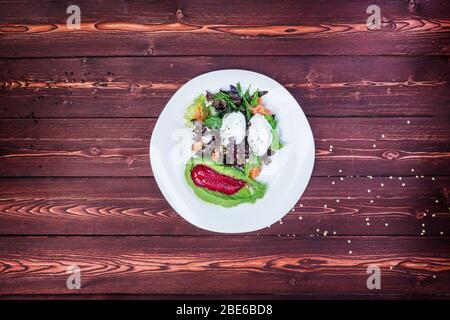 Salade avec saumon et charrue à œufs sur fond de bois. Vue de dessus Banque D'Images