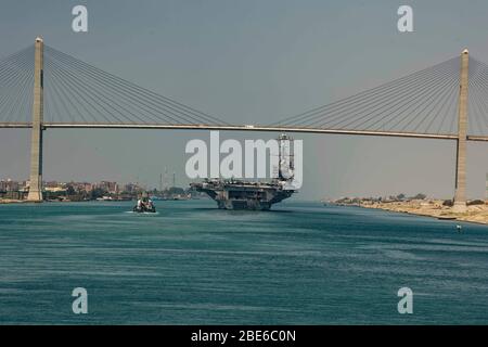 Le porte-avions de la marine américaine de classe Nimitz USS Harry S. Truman traverse sous le pont de paix de Moubarak lorsqu'il transite le canal de Suez le 2 avril 2020 à El Qantara, en Egypte. Banque D'Images