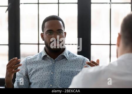 Un employé afro-américain confiant se remue avec un collègue lors de sa réunion Banque D'Images