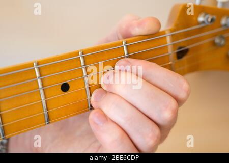 Jouer / démontrer / montrer un accord sur une guitare électrique téléaster de joueur moderne d'aile avec un seul morceau de cou d'érable et de fretboard Banque D'Images