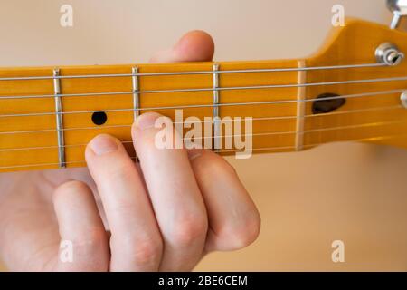 Jouer / démontrer / montrer un accord D sur une guitare électrique téléaster de joueur moderne d'aile avec un seul morceau de cou d'érable et de fretboard Banque D'Images