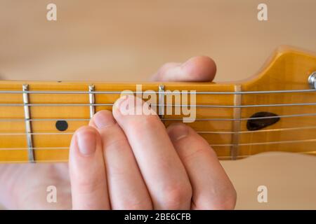 Jouer / démontrer / montrer un accord E sur une guitare électrique téléaster de joueur moderne d'aile avec un seul morceau de cou d'érable et de fretboard Banque D'Images