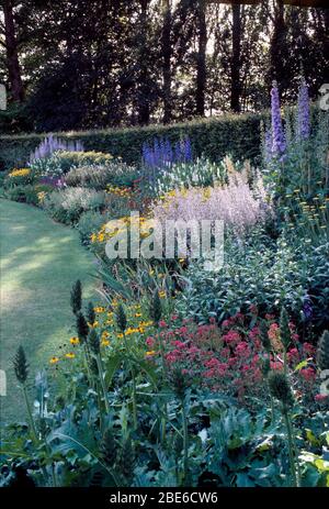 Lupins et salvia bleus à la frontière avec rudbeckia jaune et valérienne rouge dans le grand jardin de campagne Banque D'Images