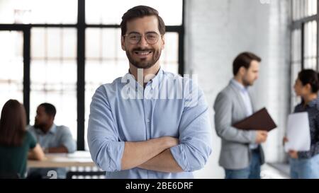 Homme souriant PDG posant seul dans un bureau moderne Banque D'Images