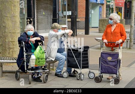 Trois personnes portant des masques, avec des chariots à provisions, pendant le verrouillage de Corona virus. Banque D'Images