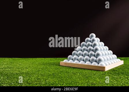 Pyramide de balles de golf dans un terrain d'exercice, fond noir, image horizontale Banque D'Images