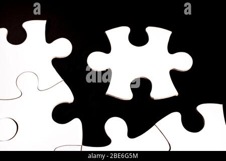 Puzzle blanc inachevé sur fond noir Banque D'Images