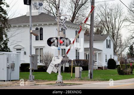 Lafox, Illinois, États-Unis. Une porte de passage à niveau descend avec des feux rouges clignotants pour avertir les automobilistes d'un train de marchandises à venir. Banque D'Images