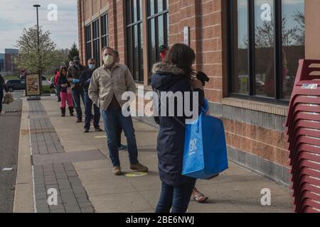 Covid-19, foule portant des masques de visage attendent en ligne pour entrer sur le marché alimentaire, banlieue de Philadelphie, PA, 11 avril 2020 Banque D'Images