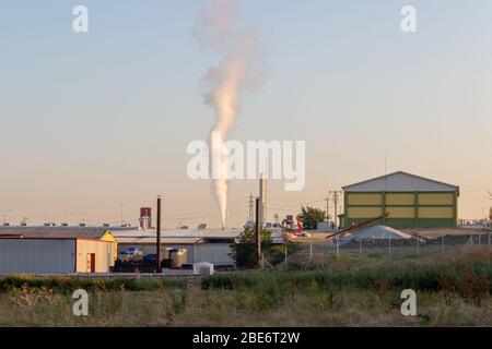 Une petite usine de produits chimiques déchère la vapeur d'échappement de sa cheminée.