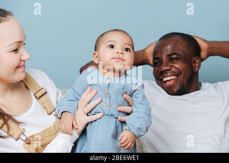 Les parents avec leur fille de bébé sur bleu. Banque D'Images