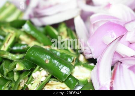 Vue rapprochée des légumes hachés.le piment vert et l'oignon sont prêts à cuisiner dans ma cuisine. Banque D'Images