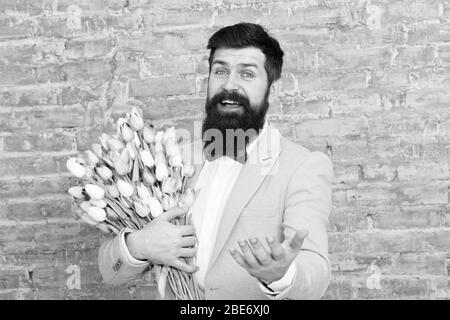 Cadeau romantique. Macho prêt date romantique. Tulipes pour ma chérie. L'homme grand Bow-tie tuxedo tenir fleurs bouquet. Comment être gentleman. Guide pour l'homme moderne. Homme romantique avec des fleurs. Banque D'Images