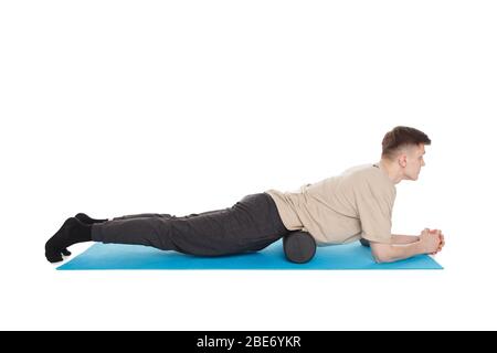 Un homme de handsome montre des exercices utilisant un rouleau en mousse pour un massage de libération myofasciale des points de déclenchement. Massage des muscles abdominaux. Isolé sur qui Banque D'Images