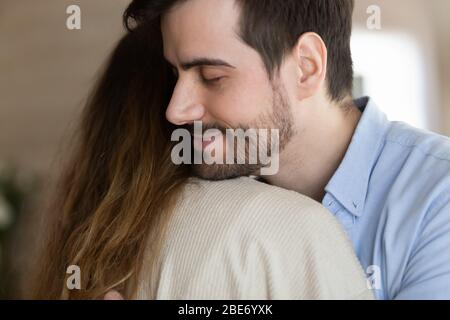 Jeune homme barbu embrassant la femme après la réconciliation. Banque D'Images