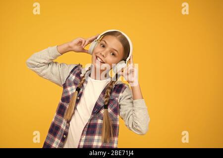 Happy little girl wearing headphones moderne. Cute kid bénéficiant d'un son stéréo. C'est la liberté sans fil. Avec la technologie sans fil. Petit enfant à écouter de la musique sans fil moderne d'écouteurs. Banque D'Images