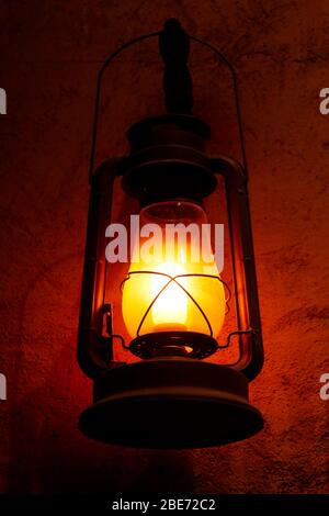 lampe lanterne ou lumière rantale pendu sur un mur dans l'obscurité Banque D'Images